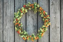 Wreath of flowers on wooden background — Stock Photo