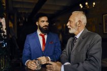 Due uomini eleganti in un bar con bicchieri — Foto stock
