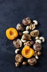 Sliced apricot, dried figs, almonds and various nuts on dark ground — Stock Photo