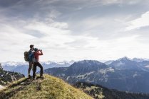 Áustria, Tirol, jovem casal em pé na paisagem montanhosa e olhando para a vista — Fotografia de Stock