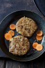 Veggie burger and carrot slices in frying pan — Stock Photo