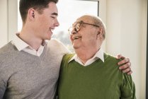 Senior homme souriant au jeune homme — Photo de stock