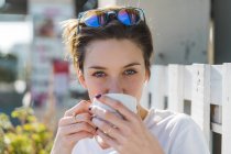 Retrato de la mujer bebiendo taza de café - foto de stock