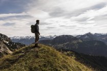 Austria, Tirolo, giovane in piedi nel paesaggio montano guardando in vista — Foto stock