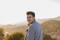 Портрет улыбающегося молодого человека на закате — стоковое фото
