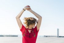 Felice giovane donna all'aperto scuotendo i capelli — Foto stock