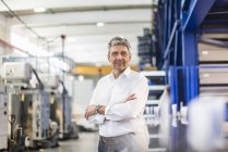 Homme d'affaires souriant dans le hall de production — Photo de stock