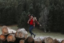 Junge Frau balanciert auf Baumstämmen — Stockfoto