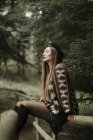 Jovem mulher na moda relaxando na floresta — Fotografia de Stock
