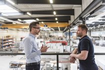 Due uomini che parlano in officina. — Foto stock
