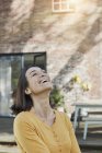 Portrait of happy woman in front of her home — Stock Photo