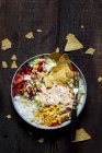 Taco salad bowl with rice, corn, chili con carne, kidney beans, iceberg lettuce, sour cream, nacho chips, tomatoes — Stock Photo