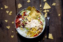 Taco-Salatschüssel mit Reis, Mais, Chili con Carne, Nierenbohnen, Eisbergsalat, Sauerrahm, Nacho-Chips, Tomaten — Stockfoto