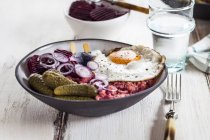 Labskaus, rollmops, pickled gherkin, beetroot salad, onion and fried egg — Stock Photo