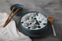 Ciotola di frullato blu con cocco grattugiato, mirtilli e palline di frutta del drago — Foto stock