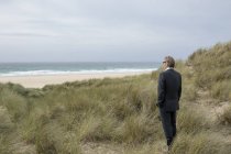 Royaume-Uni, Cornouailles, Hayle, homme d'affaires debout dans les dunes de plage et regardant la vue — Photo de stock