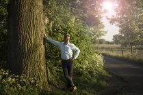 Бизнесмен, стоящий на дереве — стоковое фото