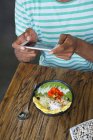 Mani maschili scattare una foto di frullato ciotola con smartphone — Foto stock