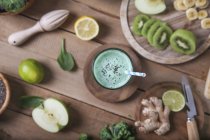 Зелений коктейль в оточенні інгредієнтів — стокове фото