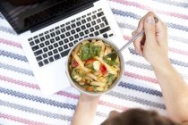 Mann isst Nudelsalat auf Decke im Park, Teilsicht — Stockfoto