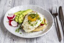 Toast with with fried egg, avocado, red radish, tomato and cress — Stock Photo