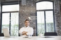 Porträt eines gestandenen Geschäftsmannes mit Laptop im modernen Büro — Stockfoto