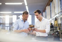 Deux hommes d'affaires en usine discutent du produit — Photo de stock