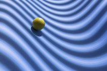Esfera amarilla sobre un fondo azul geométrico, representación 3D - foto de stock