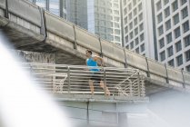 Runner in camicia da fitness blu che corre sul ponte moderno — Foto stock