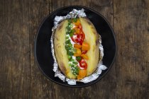 Patate cuite au four avec caillé et ciboulette, poivron, tomates et oignons de printemps — Photo de stock