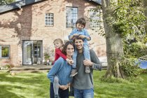 Portrait of happy family in garden of their home — Stock Photo