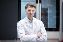 Портрет людини носіння лабораторії пальто і захисні окуляри на машині — стокове фото