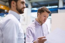 Two men in factory looking at plan — Stock Photo