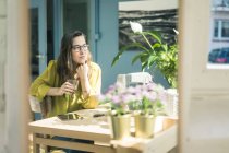 Portrait de créatrice de mode souriante assise à son bureau dans son studio — Photo de stock