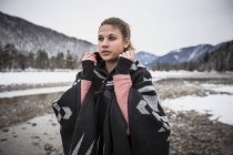 Молода жінка стоїть на річці взимку — стокове фото