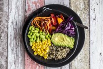 Quinoa veggie bowl of avocado, Edamame, tomatoes, corn, red cabbage and carrots — Stock Photo