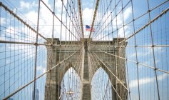 USA, New York, Brooklyn, Close up di cavi e archi in metallo Brooklyn Bridge con bandiera americana in alto — Foto stock