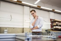 Jungunternehmer in Fabrik arbeitet nach Plan — Stockfoto