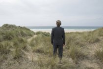 Reino Unido, Cornwall, Hayle, empresário de pé em dunas de praia e olhando para a vista — Fotografia de Stock