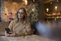 Retrato de mujer de negocios en restaurante usando teléfono celular - foto de stock