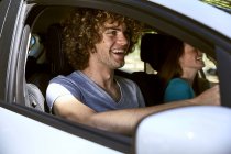 Ridere giovane coppia in auto — Foto stock