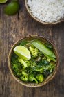 Зелений тайський каррі з брокколі, Пак Чой, сніг горох, Baby шпинат, вапно і миску рису — стокове фото