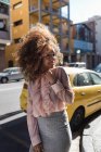 Ritratto di bella giovane donna sorridente con acconciatura afro in città — Foto stock