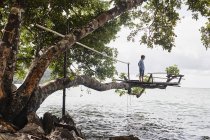 Thailand, Railay, Rai Leh East Beach, boy on tree house above the sea — Stock Photo