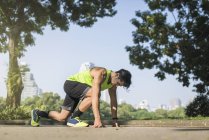 Treinamento de corredor começa posição na rua no parque urbano — Fotografia de Stock