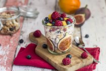 Glass of natural yogurt with granola and various fruits — Stock Photo