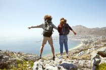 Sudáfrica, Ciudad del Cabo, pareja joven saltando de viaje en la costa - foto de stock