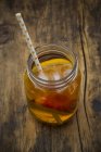 Glass of peach orange ice tea on wood — Stock Photo