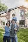 Portrait of happy family with son in garden of their home — Stock Photo