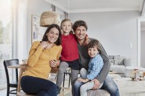 Retrato de familia feliz con dos hijos en casa - foto de stock
